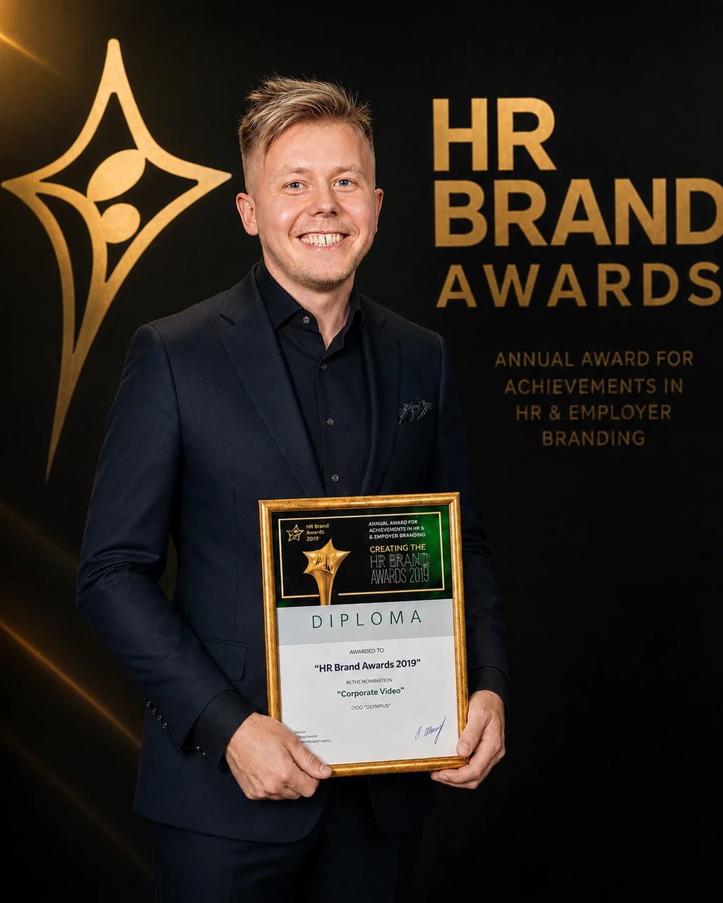 Sergéy Ulyanov holding the HR Brand Awards diploma