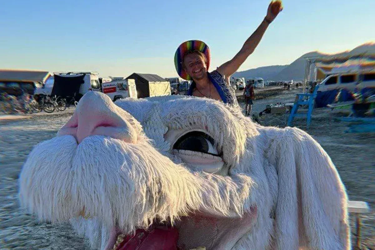 Sergéy Ulyanov with a white art creature at Burning Man in the Nasha Niva story